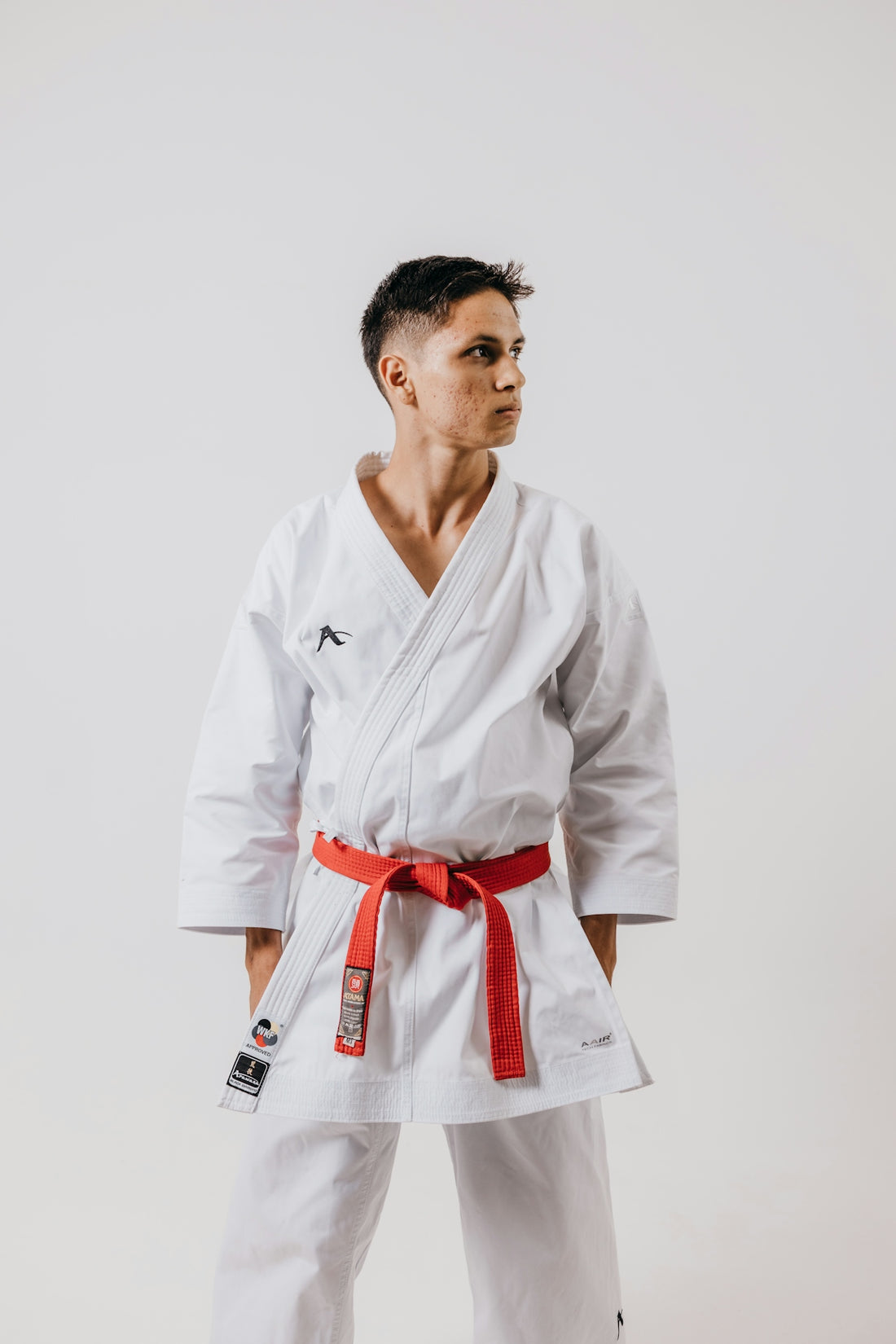 a man in a white karate suit with a red belt