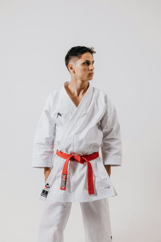 a man in a white karate suit with a red belt