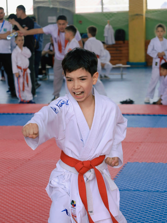 Young boy in karate uniform practicing a punch